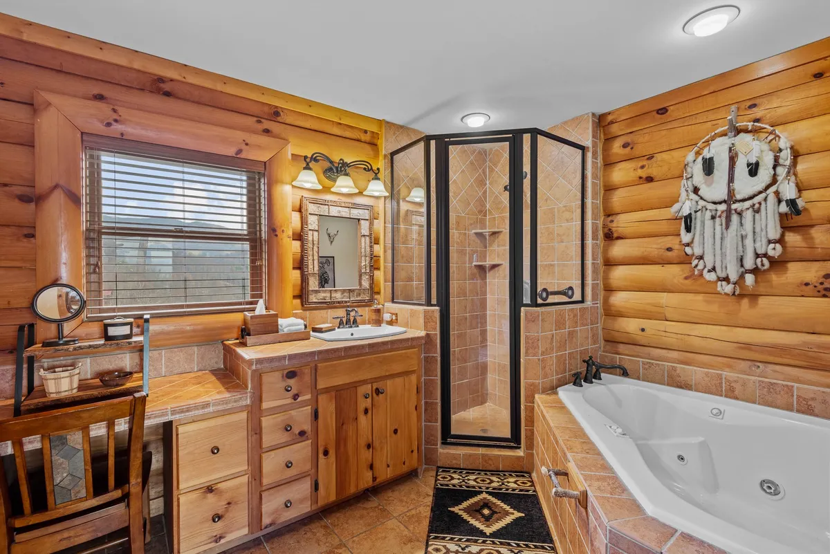 A spa-inspired bathroom with wooden cabinetry, a luxurious soaking bathtub, a glass shower enclosure, and rustic decorative elements. The mood is tranquil and indulgent, inviting moments of self-care.